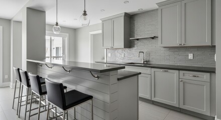Sophisticated Monochromatic Gray Kitchen with a Long Breakfast Bar and Pendant Lighting.