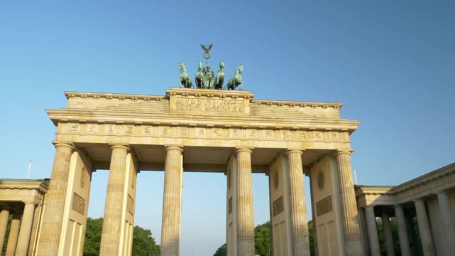 The brandenburg gate stands tall against a clear blue sky in berlin
