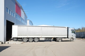 A large truck is unloading at a warehouse
