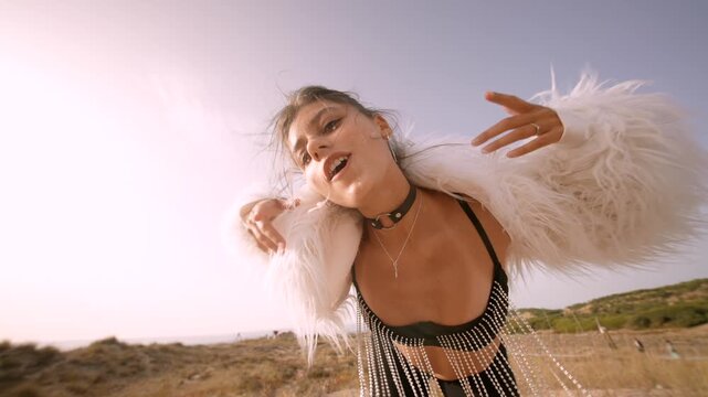 A stunning fashion model is wearing an ethereal white fur outfit set against a scenic landscape