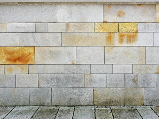 Natural stone facade with smooth slabs and yellowish-brown discoloration. Close-up. Copyspace.