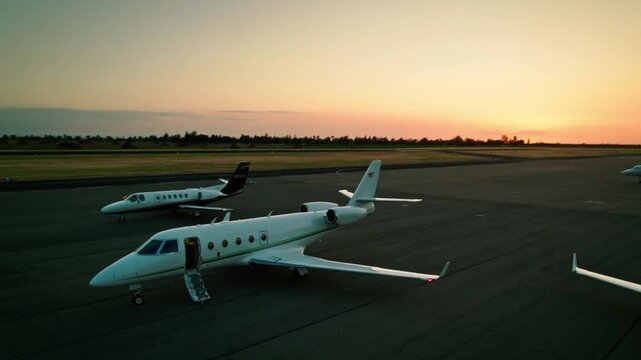 Two private jets sit parked on the tarmac ready for departure