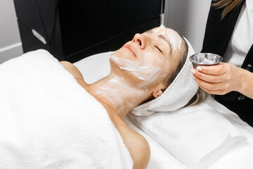 Woman receiving RF lifting facial rejuvenation treatment in a spa setting, with soothing ambiance...