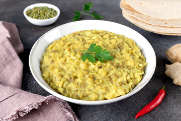 Indian Khichari with rice,lentils served with roti on gray background. Top view. Ayurveda diet