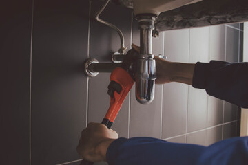 plumber at work in a bathroom, plumbing repair service , fix water plumbing leaks, replace the kitchen sink drain