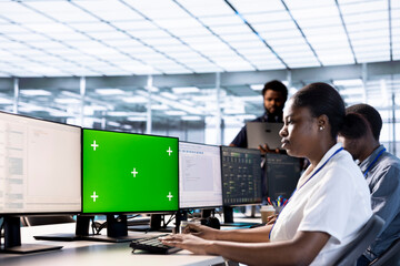 Server room technician using green screen computer to find firewall misconfigurations. Woman checking systems bottlenecks leading to sluggish data transfer rates using chroma key PC