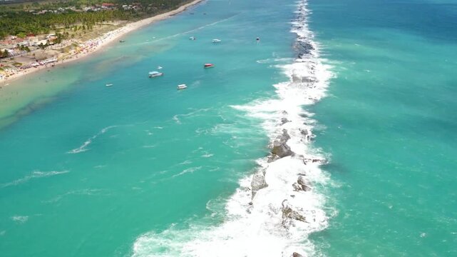 Aerial view of boats sailing on turquoise water near a tropical beach
