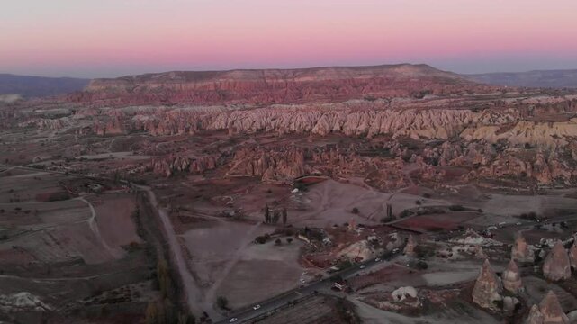 Cappadocias otherworldly landscape unfolds beneath a vibrant sunrise sky