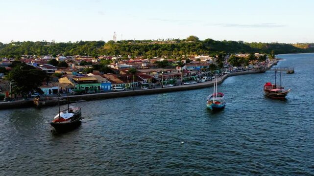 Boats sail near the coastline of a vibrant coastal town in brazil