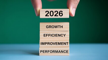 Strategically stacking wooden blocks with '2026' and key business goals like growth, efficiency, improvement, and performance signals future success and planning.