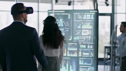 Businesspeople wearing VR headsets, looking at a large screen displaying data visualizations - Powered by Adobe