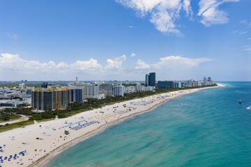 Miami beach with turquoise waters. Aerial view of sandy coastline and waves. Tropical Miami Beach scene with sandy beach. Oceanfront of South Miami. Panoramic of Miami Beach.