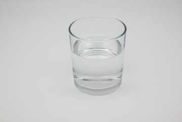 Clear glass of fresh water on white background. Concept of hydration, healthy lifestyle, mental health, nutrition, self-care, and medical wellness.
