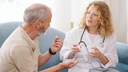 Obraz premium Female doctor explaining medicine to senior patient at home