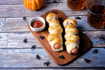 Sausages in dough with tomato sauce in the form of mummy for Halloween holidays