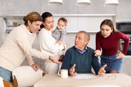 People of different generations argue with each other and show an elderly father how to fill out documents correctly