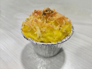 Mashed potatoes with grated cheese in a silver bowl on the table