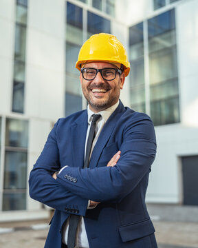 Professional engineer smiling in suit wearing hard hat