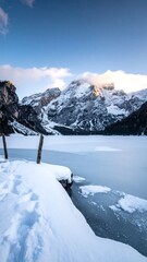 Frozen lake at sunrise, snow-covered mountains