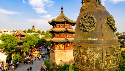 Ornate pagoda towers over a crowded cityscape with an embossed bronze bell foreground