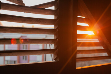 A view of the sunset from the attic through a loft window for ventilation, a beautiful red sunset in backlight
