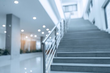 Obraz premium Blurred view of steps with metal railing in what appears to be a modern building or office