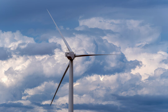 Rear view of wind turbine against dramatic storm clouds