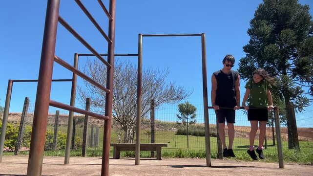 pai e filha fazem exerc&iacute;cios juntos em barras 