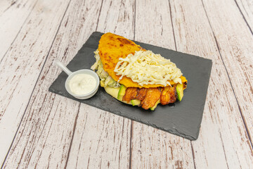 Traditional Venezuelan cachapa folded with fresh white cheese, butter, and papelón, accompanied by coffee with milk