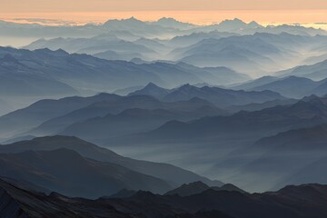 Misty mountain ranges layered in shades of blue and grey at sunrise