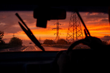 view from a car on the highway in bad weather conditions, rain and fog, at a beautiful red sunset