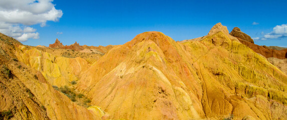 Colorful Fairytale rainbow canyon panorama landscape in Kyrgyzstan. Orange and yellow mountain...