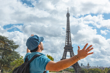 Turista disfrutando de la Torre Eiffel en París, con boina azul parisina y sonrisa alegre. © ismel leal