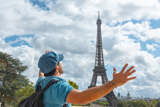 Turista disfrutando de la Torre Eiffel en Par&iacute;s, con boina azul parisina y sonrisa alegre.