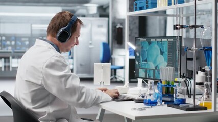 Atypical researcher uses headset for focus music during experiment, distinct approach in laboratory science. Unique scientist combines originality with genetics research at work. Camera B.