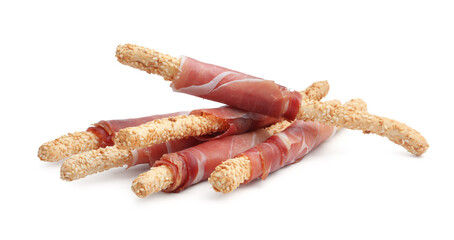 Delicious grissini sticks with sesame seeds and prosciutto isolated on white