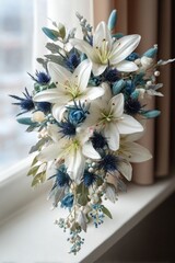A delicate floral bouquet, cascading with white lilies and deep blue thistle, creates a serene and elegant display.