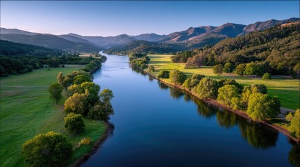 Scenic River Valley at Sunrise with Towering Mountains Lush Greenery and Golden Sunlight Casting a Warm Glow on the Water and Surrounding Landscape