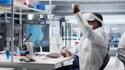 African american expert using VR glasses in lab for molecular research, virtual reality gadgets helping with biotechnology and genetics research. Modern interactive tech in laboratory. Camera B. - Powered by Adobe