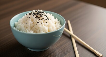 Steamed rice with black sesame in ceramic bowl with chopsticks aside