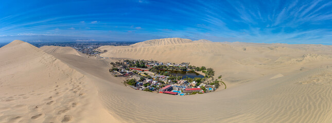 Oasis Huacachina high resolution wide angle panoramic landscape. Sand dunes dry desert in Peru. Peruvian natural wonder in the desert near the city Ica. Oasis lake in the middle of sand dunes