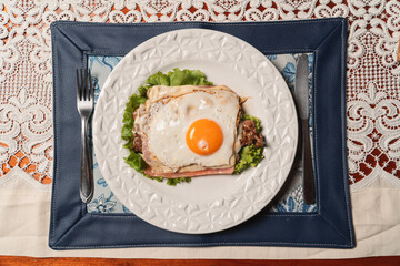 Bird's-eye view of a breaded cutlet with fried egg on a restaurant table.