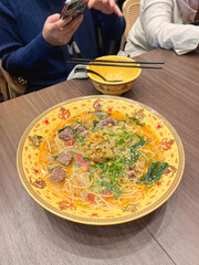 The broth soup contains instant noodles, beans, fresh vegetables and meat.