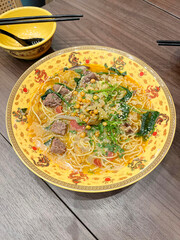 The broth soup contains instant noodles, beans, fresh vegetables and meat.