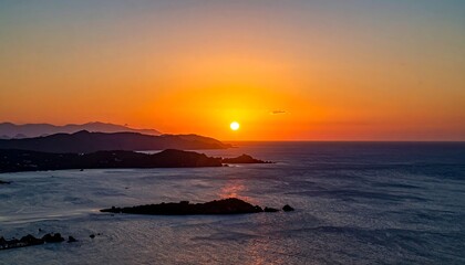 Vibrant sunset over calm ocean, islands silhouetted against fiery sky