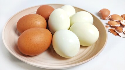 Close up of Peeled and unpeeled boiled chicken egg in white plate. Isolated on white background with copy space. Suitable for editing and used for food and nutrition advertising.