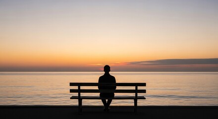 Silhouette of person on bench facing ocean sunset