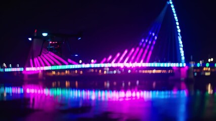 Nighttime drone view of illuminated bridge over water