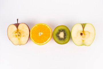 Sliced red apple, orange, kiwi, and green apple display colorful contrast in a horizontal line arrangement.
