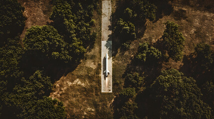 Aerial view of a road cutting through a dense forest setting.